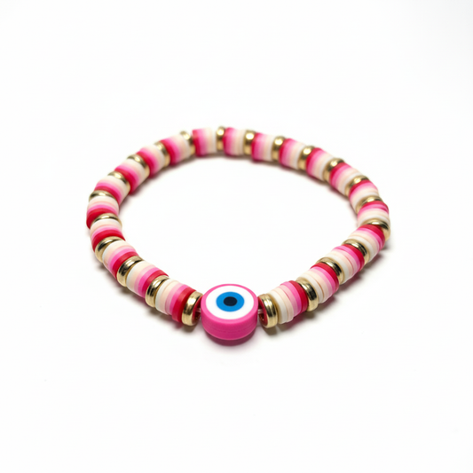 Handmade pink evil eye bracelet with striped disc beads and gold spacer rings on a bright white background